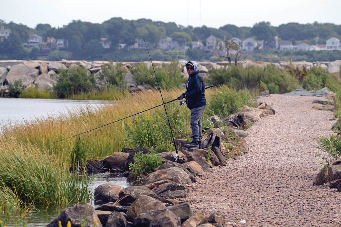 NEW LIFE: A fisherman (who declined to identify himself) peacefully watches his lines from the newly refurbished causeway leading to the breakwater at Salter Grove Memorial Park while finishing up a morning of fishing.